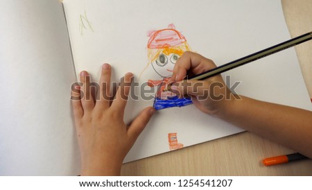 The point of view of the child, who paints with colored pencils. Childhood and children education concept.