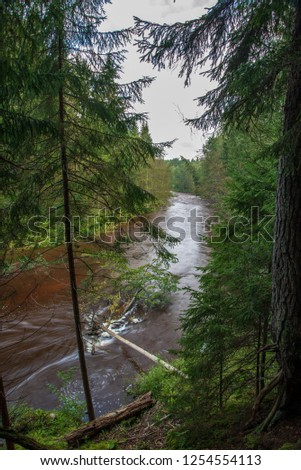 fast river in forest. Amata in Latvia with high water and rapid stream ready for kayaking in green summer. long exposure