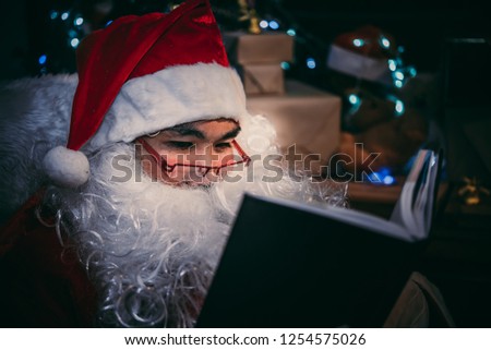 Portrait of Happy santa clause reading a book,Thailand people wear santa claus dress,Sent happiness for children,Merry christmas,Welcome to winter
