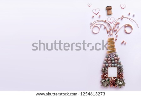 Decorations and heart shape ribbons exploding from a bottle of champagne with background space
