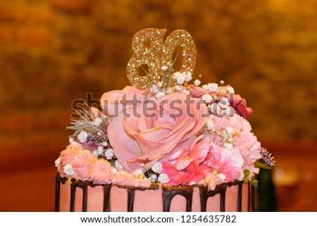 Pink birthday cake with live rose flowers