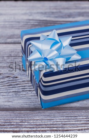 Gift box with blue bow. Elegant gift box on wooden background. Festive present with clipping path.