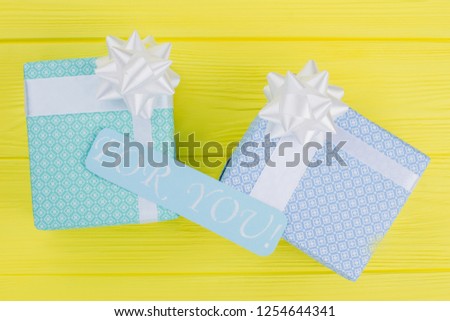 Valentines Day gift boxes and romantic card. Beautifully packed gift boxes on yellow background. Valentine holiday gift concept.