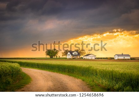 Country Road with the Idyllic Midwestern Farmhouse Background