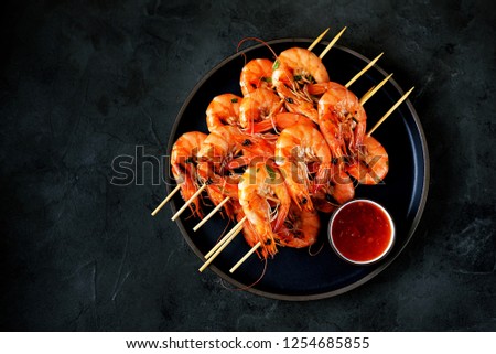 Large grilled prawns on wooden skewers. Shrimp kebabs. Top view. Copy  space. 