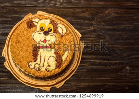 Birthday cake with dog print on a black wooden table
