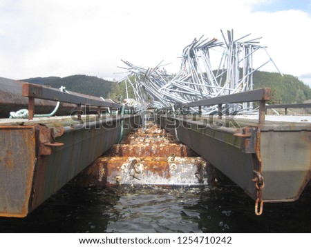 Port Harvey's derelict fish farm in a remote inlet off Johnstone Strait halfway between Campbell River and Port Hardy shows no sign of recycling activity. The structures are taken over by marine live.