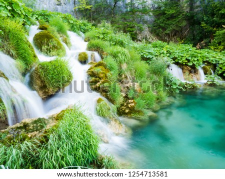 water cascades in beautiful grass environment of plitvice lakes 