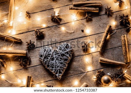 Heart shape decoration and Christmas lights around on wooden background