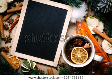 Christmas decoration and tea near menu board on wooden background