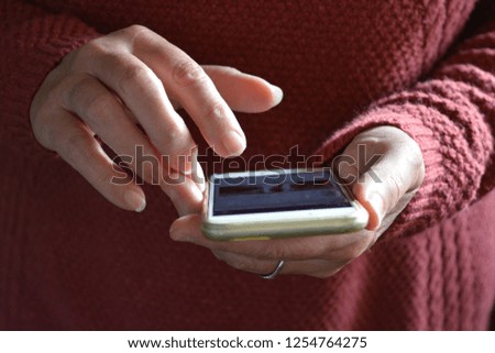 Woman using a smartphone, finger poised over touchscreen