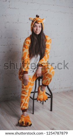 pajamas in the form of a giraffe. emotional portrait of a girl on a gray background. crazy and funny man in a suit. clean skin and long hair. animator for children's parties