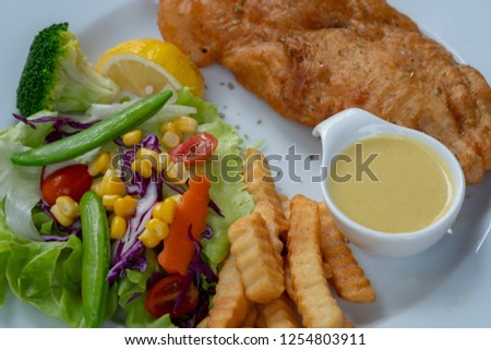 close-up of fish and chips with fresh salad