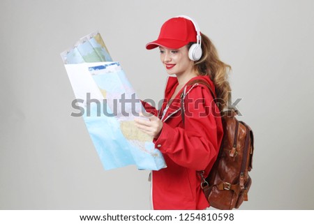 Traveller women in red dresses, backpacking, light grey background.