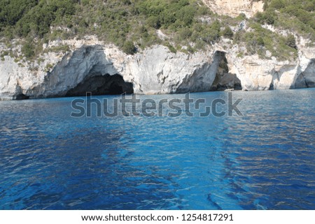 view of caves along the coastline from a boat at sea