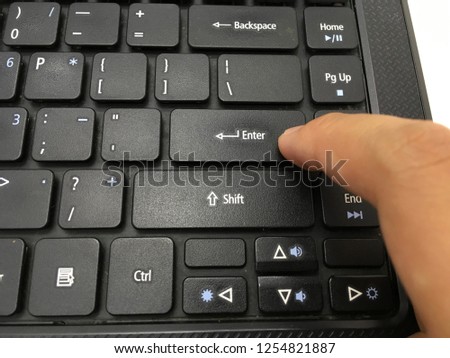 Closeup image of hands typing enter button on laptop keyboard on white background.