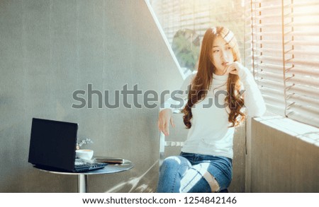 youngfemale working and relax in cafe with laptop and coffee on glass table