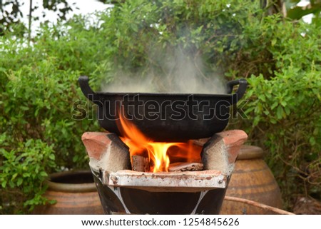 this pic show the Cooking on pot on the Charcoal oven at open kitchen, this is traditional local cook of Thailand rural area