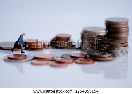 Miniature people : Business man standing on coins stacks. Picture user for success, dealing, partner, greeting and business competition winner concept.