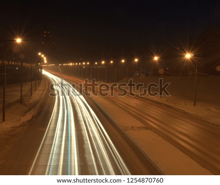 Light tracks from the headlights of cars passing by. The picture was taken at night on a long exposure. Bugrinsky Bridge, Novosibirsk, Russia.
