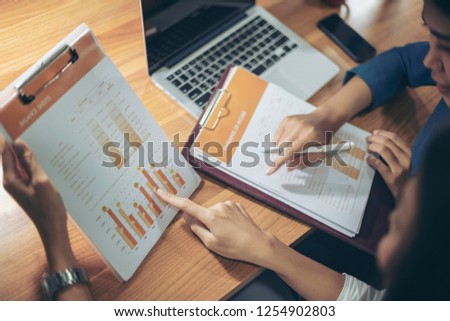 Businessman giving presentation on paper charts to colleagues in office. Business meeting time. Idea presentation, analyze plans.