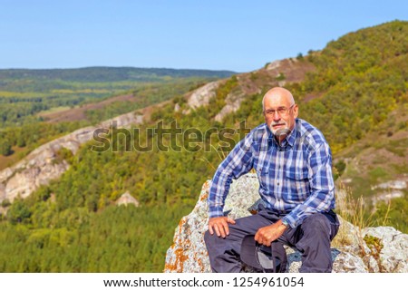 Portrait of a tired bearded man on the background of the Ural taiga.