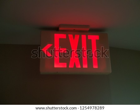 Glowing red exit sign. Royalty-Free Stock Photo #1254978289