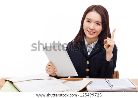 Young Asian student girl using tablet PC on the desk isolated on white background.