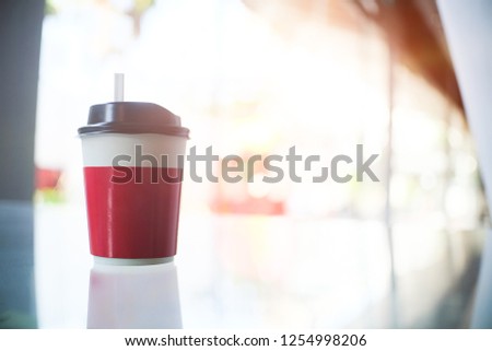 Hot drink coffee cup near glass window and  blur background.