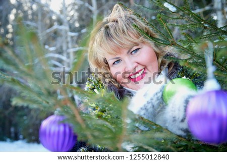 Plump woman in the winter forest with Christmas toys. Christmas and New year concept