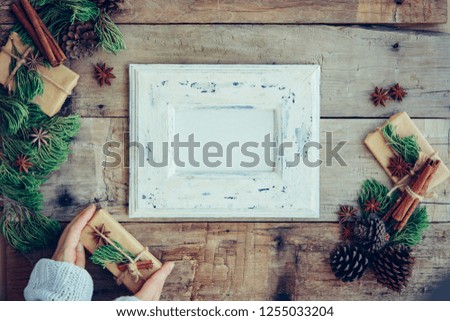 White photo frame with christmas decoration on the wooden table. Holiday mock up. Scandinavian style.