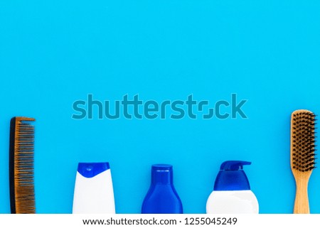 Male care set for barbershop with shampoo bottle and comb on light blue background top view mock-up