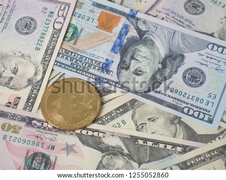 Concept shot of American US dollar bank notes as background and Bitcoin on top on the left side