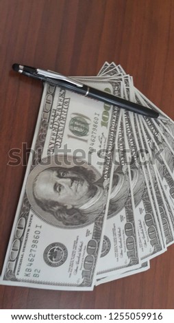 Close up of a pen on the background of dollars