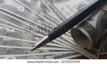 Close up of a pen on the background of dollars