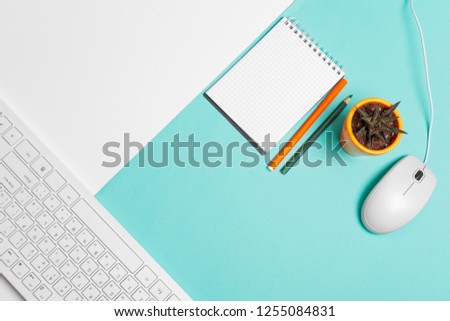 Computer keyboard and mouse on color block background, office interior