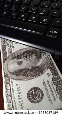 Hundred dollar bills, keyboard calculator and female hand on computer