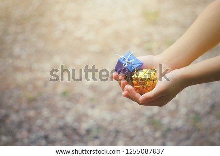 close  up kid hand holding small gift box, copy space background for text, countdown to holiday season, merry christmas, happy new year 2019 concept