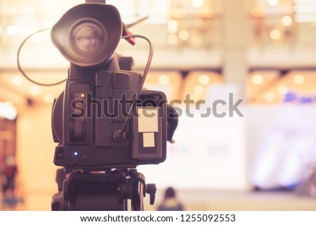 Blurred of Video camera recording film shooting of grand opening in conference hall Live streaming wifi microphone sending for presentation with bokeh light background. Media Production Process Concept