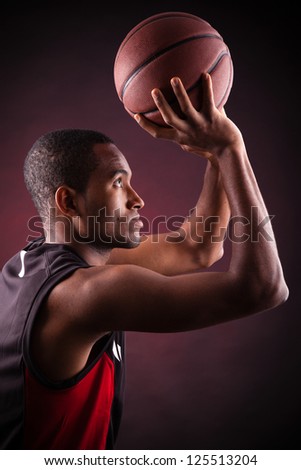 young male basketball player against black background