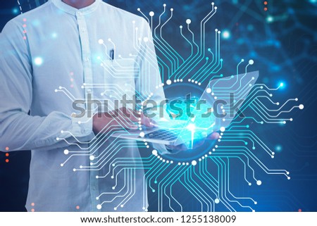 Unrecognizable businessman with laptop standing over dark blue background with brain interface in front of him. Artificial intelligence concept. Toned image double exposure