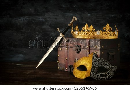 low key image of beautiful queen/king crown, mysterious mask and sword. fantasy medieval period