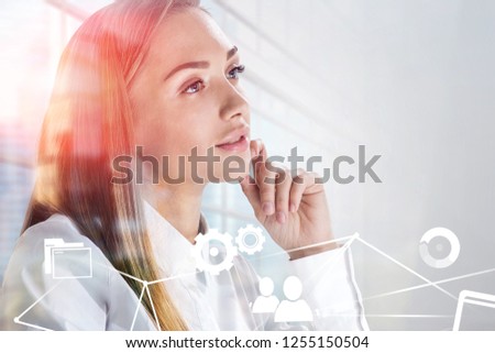 Thoughtful young businesswoman portrait over skyscraper background with double exposure of business interface. Toned image