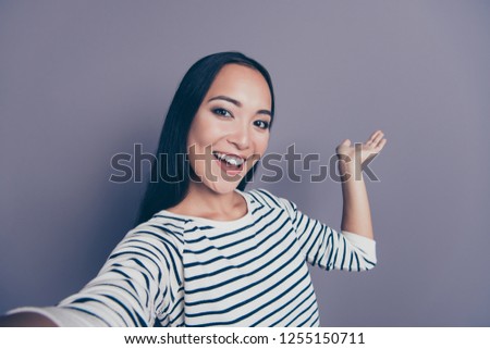 Self-portrait of nice cute lovely attractive adorable stylish positive cheerful optimistic straight-haired lady in striped pullover showing holding way direction object isolated on gray background