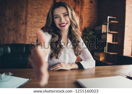 Portrait of nice lovely attractive adorable charming magnificent glamorous cheerful positive wavy-haired lady ceo boss chief director welcoming hand shake at work place station