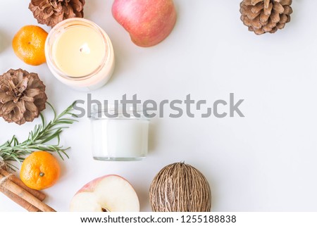 Candle, pine, apple, cinnamon on the white table. Space for text Royalty-Free Stock Photo #1255188838