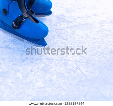 Legs of an ice skater in old vintage skates. Ice skratched background.