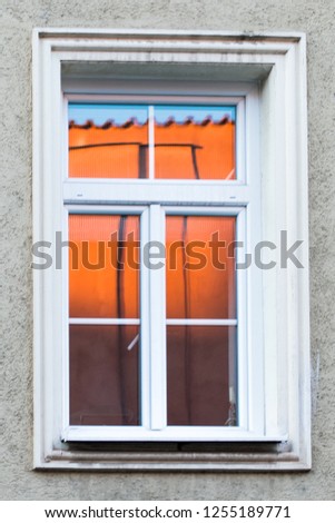 A window with a orange reflection. 