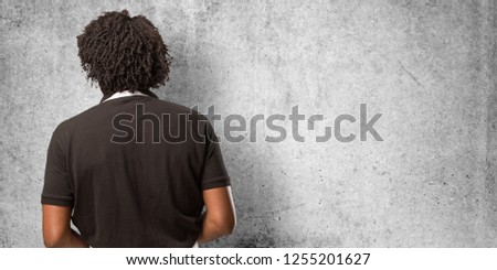 Handsome african american baker showing back, posing and waiting, looking back