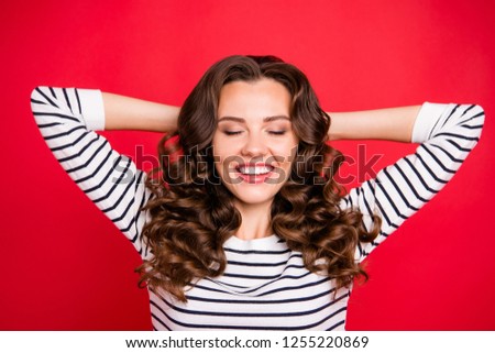 Close up photo of cute attractive beautiful she her woman holding hands behind head eyes closed making christmas wish in white striped pullover isolated on red vivid bright background